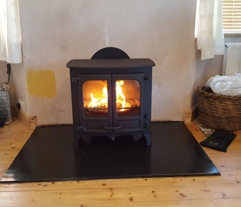 Charnwood Island 2 Stove - with low legs in black installed by our fitters with slate hearth between Esher and Kingston-upon-Thames.